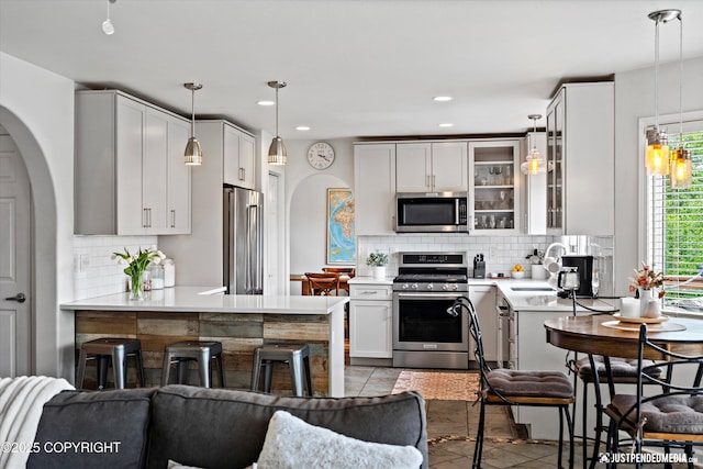 15250 Evergreen Ridge St, Anchorage, AK 99516 - kitchen with stainless steel appliances, backsplash, light countertops, glass insert cabinets, and recessed lighting