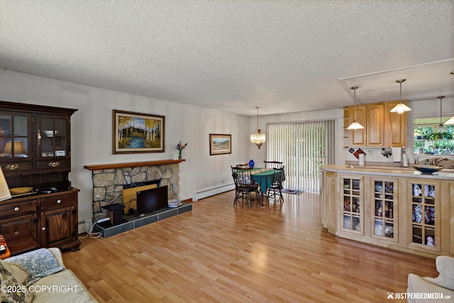 3217 Purdue St, Anchorage, AK 99508 - living room with a textured ceiling, light wood-style floors, a baseboard heating unit, and a stone fireplace