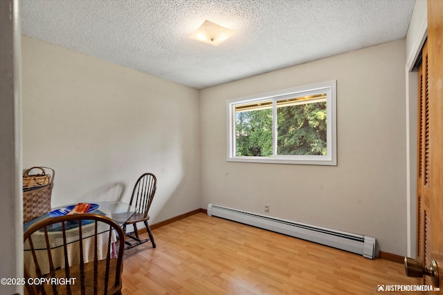 3217 Purdue St, Anchorage, AK 99508 - bedroom with a baseboard radiator, light wood-style flooring, a textured ceiling, and a closet