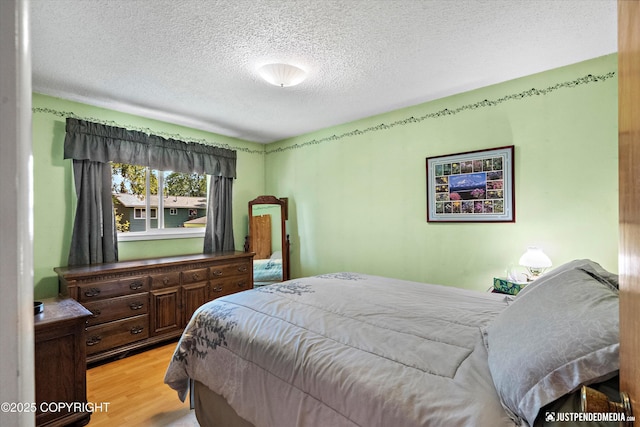 3217 Purdue St, Anchorage, AK 99508 - bedroom featuring light wood-style flooring and a textured ceiling