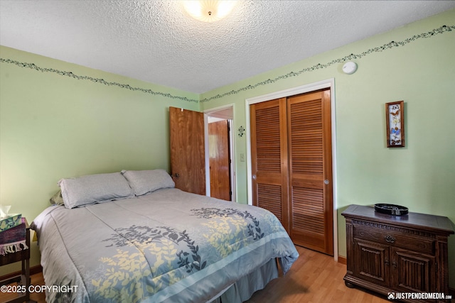 3217 Purdue St, Anchorage, AK 99508 - bedroom with a closet, light wood finished floors, and a textured ceiling