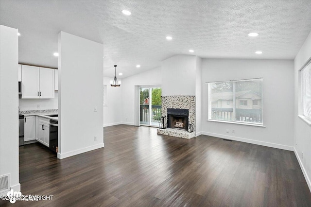 1928 Commodore Dr, Anchorage, AK 99507 - unfurnished living room featuring vaulted ceiling, dark wood-style floors, a chandelier, a tile fireplace, and a textured ceiling