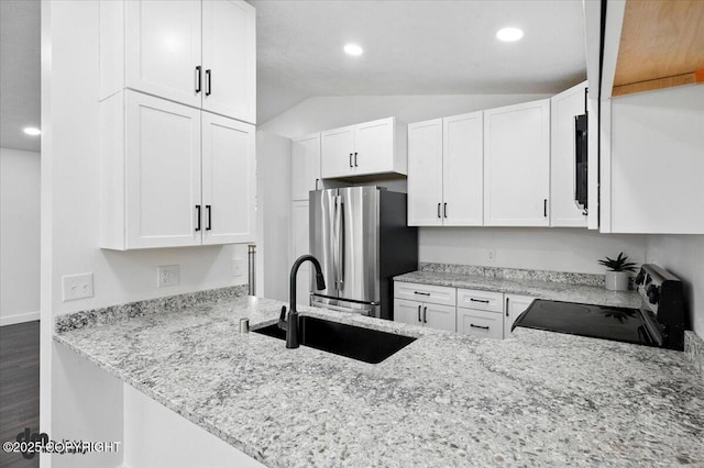 1928 Commodore Dr, Anchorage, AK 99507 - kitchen with freestanding refrigerator, stove, lofted ceiling, light stone counters, and white cabinetry
