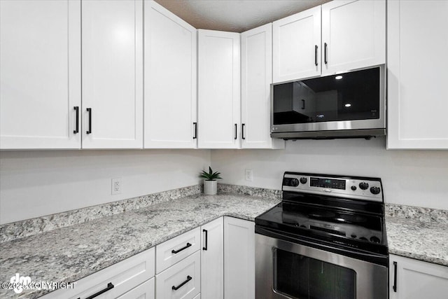 1928 Commodore Dr, Anchorage, AK 99507 - kitchen with appliances with stainless steel finishes, white cabinets, and light stone countertops