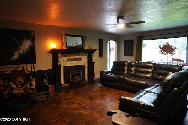 2600 Birch St, Seward, AK 99664 - living area with a ceiling fan, a textured ceiling, and a fireplace with flush hearth