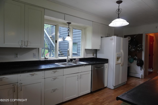 2600 Birch St, Seward, AK 99664 - kitchen with dishwasher, dark countertops, wood finished floors, white refrigerator with ice dispenser, and white cabinetry
