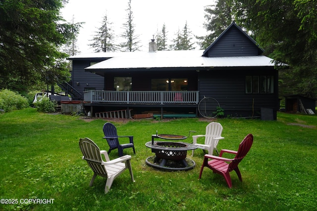 2600 Birch St, Seward, AK 99664 - back of house featuring an outdoor fire pit, a lawn, a chimney, a wooden deck, and a metal roof