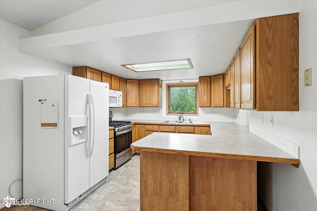 840 N Voss Cir, Wasilla, AK 99623 - kitchen with white appliances, a peninsula, brown cabinetry, and light countertops