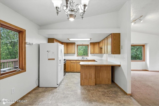 840 N Voss Cir, Wasilla, AK 99623 - kitchen featuring white fridge with ice dispenser, lofted ceiling, a peninsula, stainless steel range with gas cooktop, and a chandelier