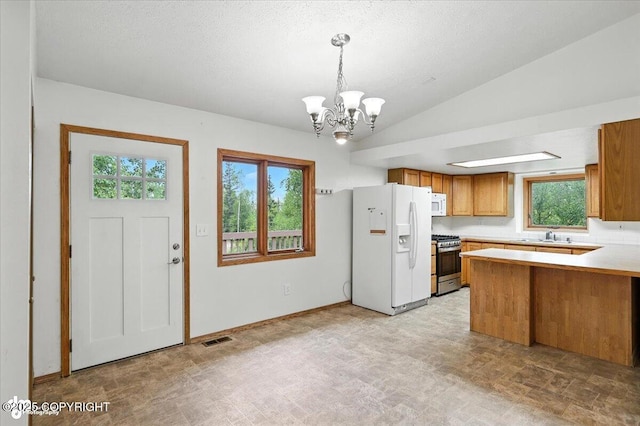 840 N Voss Cir, Wasilla, AK 99623 - kitchen with white appliances, brown cabinetry, a chandelier, a peninsula, and light countertops