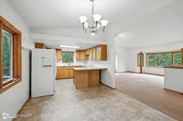 840 N Voss Cir, Wasilla, AK 99623 - kitchen featuring freestanding refrigerator, lofted ceiling, a peninsula, open floor plan, and a chandelier