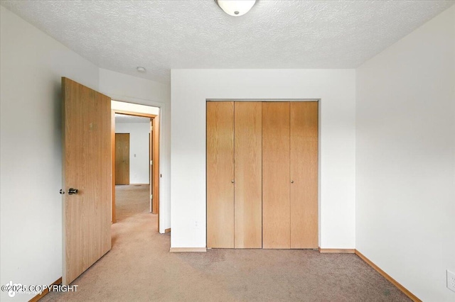 840 N Voss Cir, Wasilla, AK 99623 - unfurnished bedroom with light colored carpet, a closet, and a textured ceiling