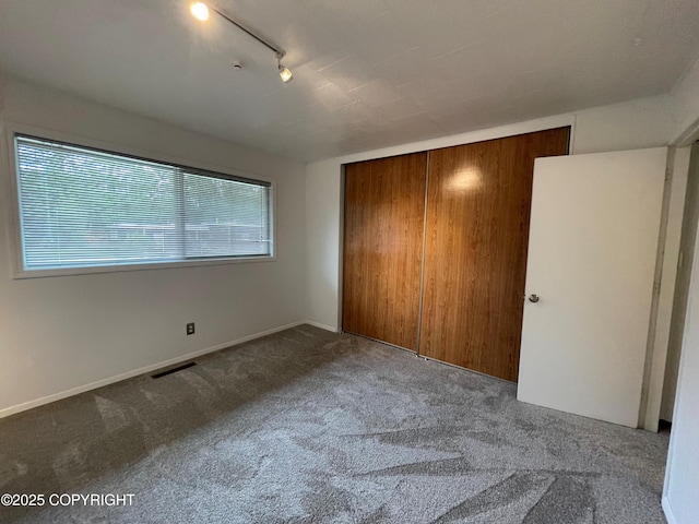 634 W 18th Ave, Anchorage, AK 99503 - unfurnished bedroom with carpet flooring, track lighting, and a closet