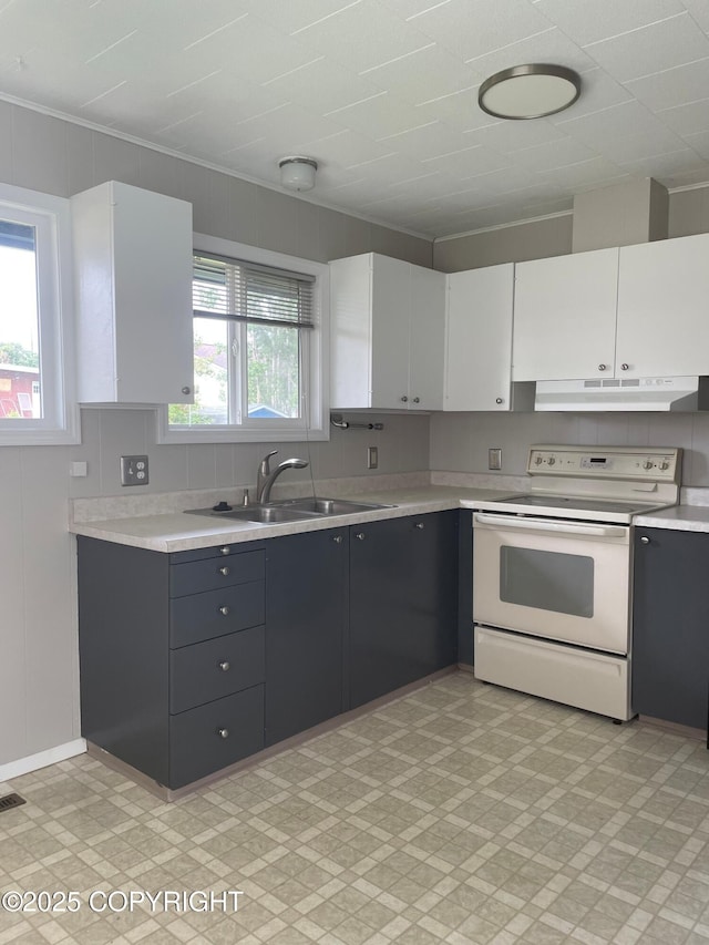 634 W 18th Ave, Anchorage, AK 99503 - kitchen with white range with electric cooktop, light floors, light countertops, under cabinet range hood, and white cabinets