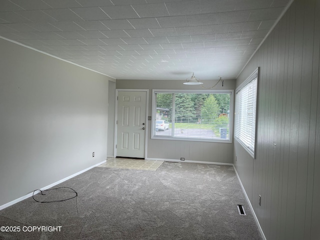 634 W 18th Ave, Anchorage, AK 99503 - empty room with plenty of natural light, carpet flooring, and wood walls
