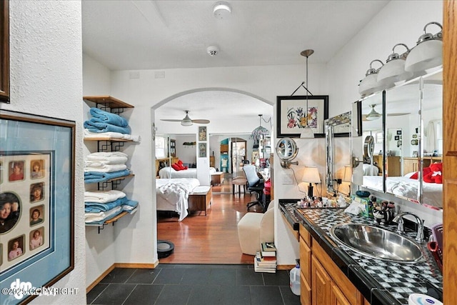 35485 Bluff Ct, Sterling, AK 99672 - kitchen featuring arched walkways, ceiling fan, dark tile patterned floors, open floor plan, and brown cabinetry