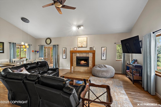 5170 Merle Cir, Anchorage, AK 99507 - living room with lofted ceiling, healthy amount of natural light, a ceiling fan, light wood finished floors, and a tiled fireplace