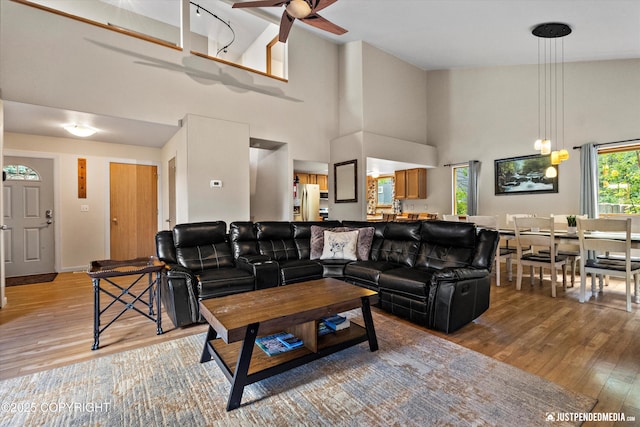 5170 Merle Cir, Anchorage, AK 99507 - living area with light wood-style floors, ceiling fan, and a towering ceiling