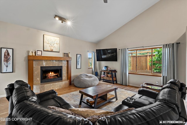 5170 Merle Cir, Anchorage, AK 99507 - living room featuring wood finished floors, a tile fireplace, and high vaulted ceiling