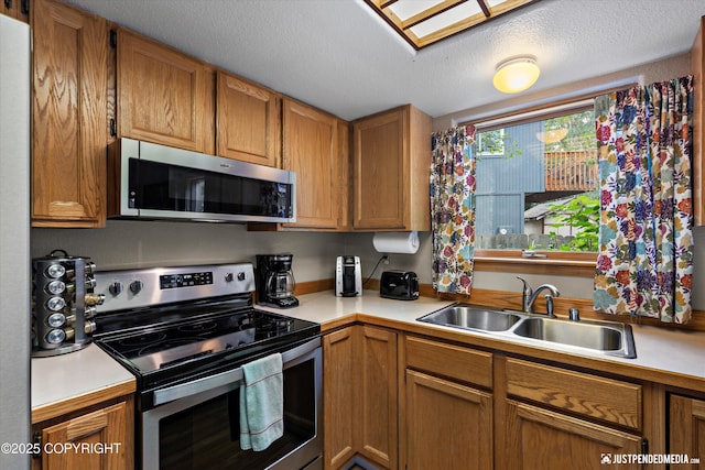 5170 Merle Cir, Anchorage, AK 99507 - kitchen with appliances with stainless steel finishes, light countertops, brown cabinets, and a textured ceiling