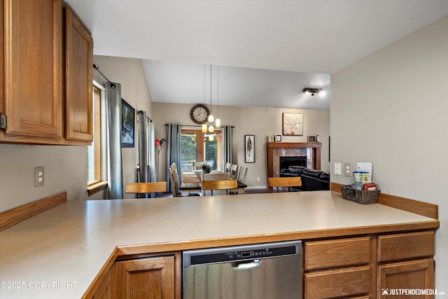 5170 Merle Cir, Anchorage, AK 99507 - kitchen with stainless steel dishwasher, a tiled fireplace, light countertops, and brown cabinets