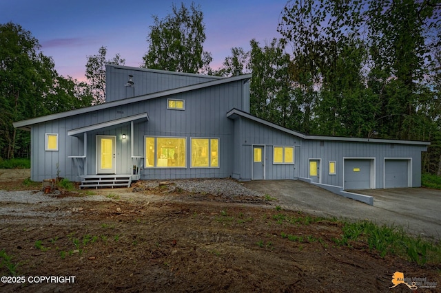 9601 Carlson Rd, Anchorage, AK 99507 - view of front of property with board and batten siding, a garage, and asphalt driveway