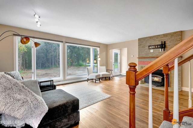 9601 Carlson Rd, Anchorage, AK 99507 - living room featuring wood finished floors, a baseboard heating unit, and stairs