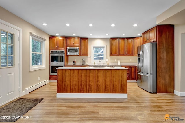 9601 Carlson Rd, Anchorage, AK 99507 - kitchen with stainless steel appliances, a baseboard radiator, light countertops, recessed lighting, and plenty of natural light