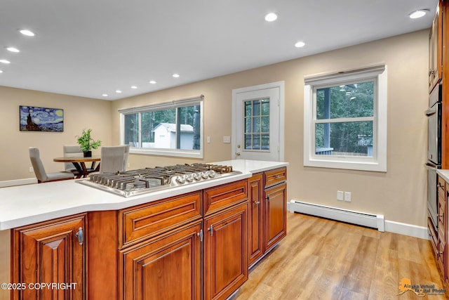 9601 Carlson Rd, Anchorage, AK 99507 - kitchen featuring stainless steel appliances, a baseboard heating unit, recessed lighting, light wood-style flooring, and light countertops