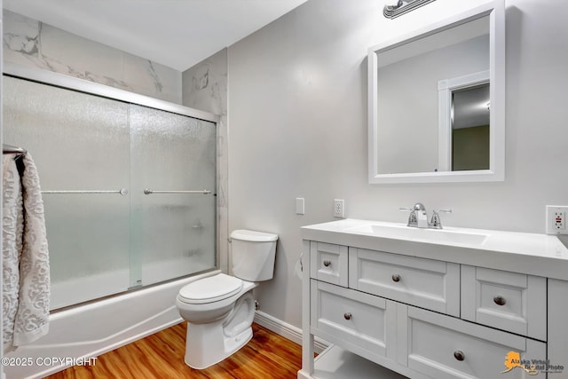 9601 Carlson Rd, Anchorage, AK 99507 - bathroom featuring wood finished floors, vanity, and bath / shower combo with glass door