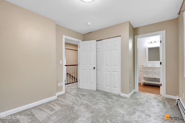 9601 Carlson Rd, Anchorage, AK 99507 - unfurnished bedroom featuring carpet floors, a closet, ensuite bath, and a baseboard radiator