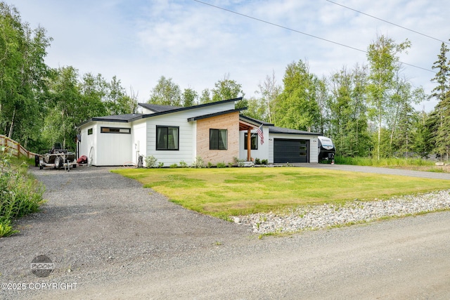 3200 E Woodruff Loop, Wasilla, AK 99654 - view of front of house featuring driveway, an attached garage, a front yard, and view of wooded area