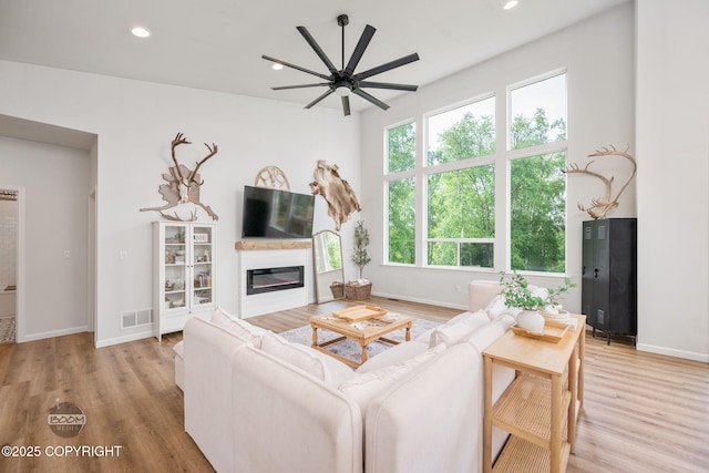 3200 E Woodruff Loop, Wasilla, AK 99654 - living area featuring a glass covered fireplace, a ceiling fan, light wood-style flooring, and recessed lighting