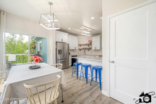 4228 E Serendipity Loop, Wasilla, AK 99654 - kitchen with stainless steel fridge, open shelves, a breakfast bar area, backsplash, and light countertops