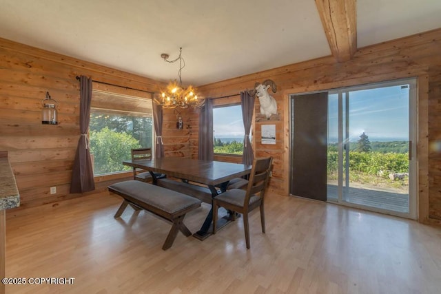 17751 Arcturus Loop, Ninilchik, AK 99639 - dining area featuring a chandelier, light wood-type flooring, wooden walls, and beamed ceiling
