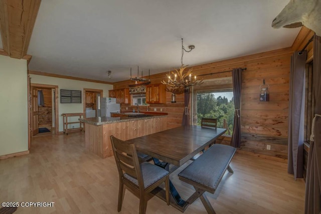 17751 Arcturus Loop, Ninilchik, AK 99639 - dining room featuring a chandelier, light wood-type flooring, ornamental molding, wood walls, and washer / clothes dryer