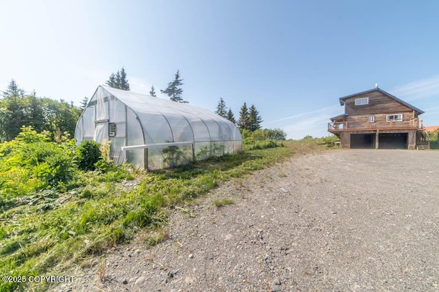 17751 Arcturus Loop, Ninilchik, AK 99639 - view of property exterior featuring a greenhouse, an outbuilding, and dirt driveway
