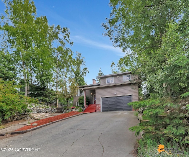 4023 Apollo Dr, Anchorage, AK 99504 - view of front of home featuring driveway, an attached garage, and a chimney