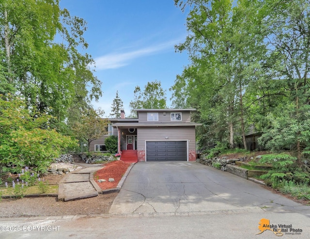 4023 Apollo Dr, Anchorage, AK 99504 - tri-level home featuring a garage, asphalt driveway, and a chimney
