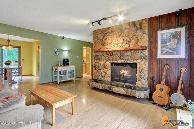 4023 Apollo Dr, Anchorage, AK 99504 - living area featuring a fireplace, wood finished floors, rail lighting, and a chandelier