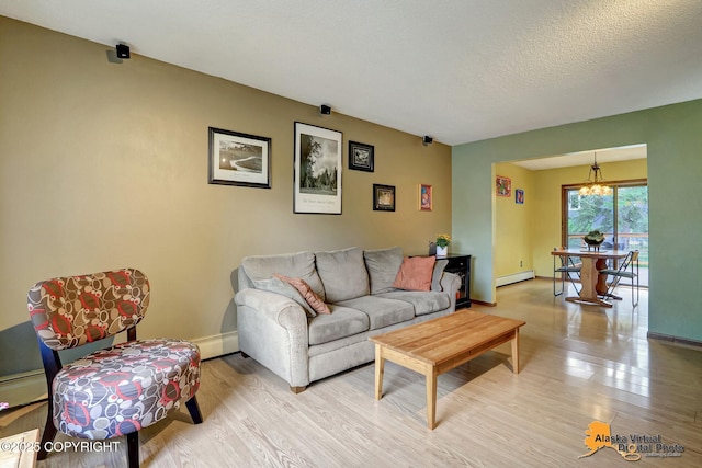 4023 Apollo Dr, Anchorage, AK 99504 - living area with a chandelier, a baseboard heating unit, light wood-style floors, and a textured ceiling
