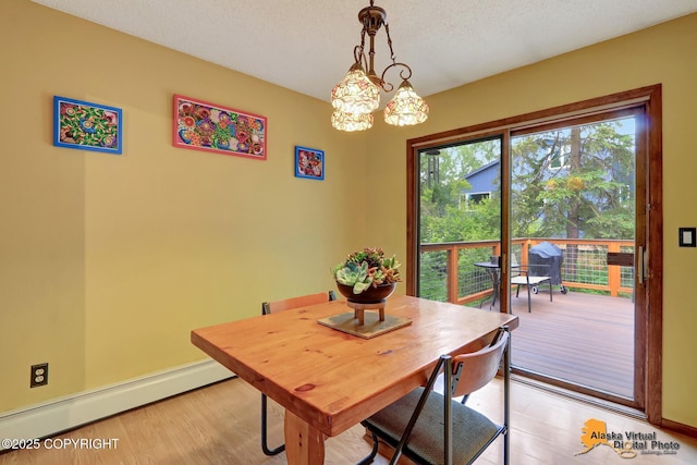 4023 Apollo Dr, Anchorage, AK 99504 - dining room featuring a baseboard heating unit, light wood-type flooring, and a chandelier