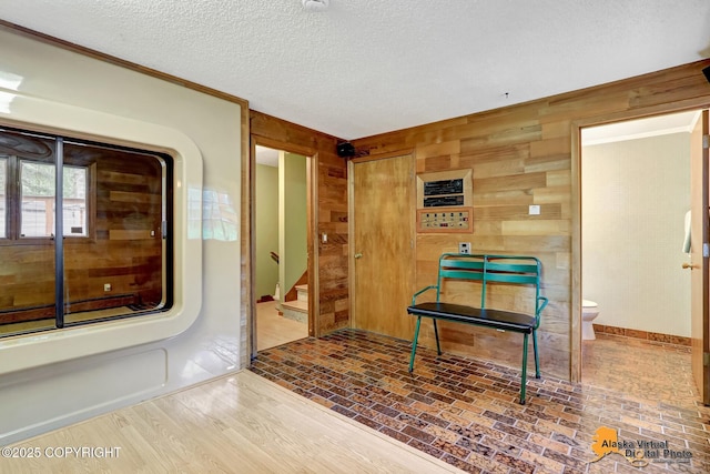 4023 Apollo Dr, Anchorage, AK 99504 - entryway featuring wood walls, a textured ceiling, brick patterned flooring, and stairway