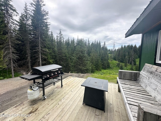 5705 Felix Cir, Homer, AK 99603 - deck with a view of trees, area for grilling, and a fire pit