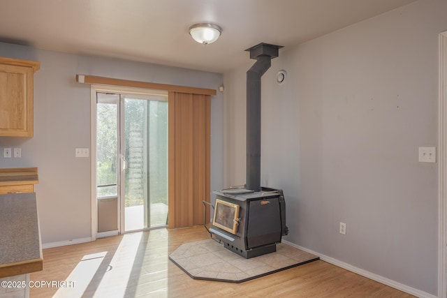 1250 Toolik Dr, North Pole, AK 99705 - unfurnished living room with a wood stove, plenty of natural light, and light wood finished floors