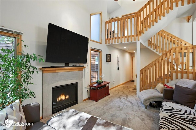 6712 Lunar Dr # K2, Anchorage, AK 99504 - carpeted living area featuring a tile fireplace, a high ceiling, and stairs