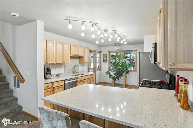6712 Lunar Dr # K2, Anchorage, AK 99504 - kitchen with light brown cabinets, appliances with stainless steel finishes, a peninsula, decorative backsplash, and light stone counters