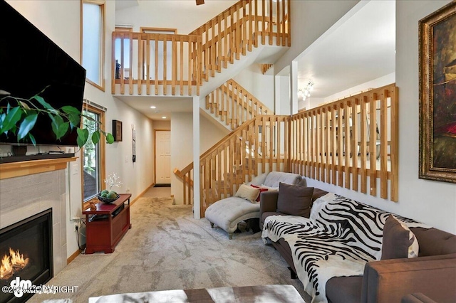 6712 Lunar Dr # K2, Anchorage, AK 99504 - carpeted living room featuring stairway, a glass covered fireplace, and a high ceiling