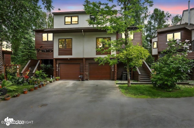 6712 Lunar Dr # K2, Anchorage, AK 99504 - view of front facade with stairway, asphalt driveway, and an attached garage