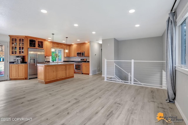 8461 Greenhill Way, Anchorage, AK 99502 - kitchen with appliances with stainless steel finishes, light wood finished floors, a center island, recessed lighting, and glass insert cabinets